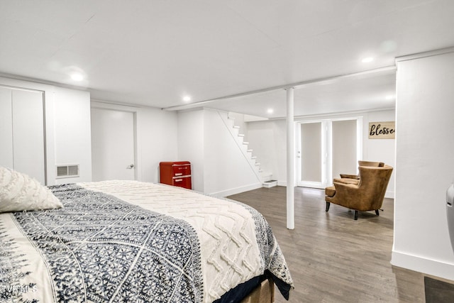 bedroom with recessed lighting, wood finished floors, visible vents, and baseboards