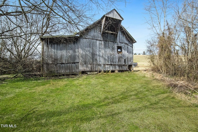 view of home's exterior featuring an outbuilding, a lawn, and a barn