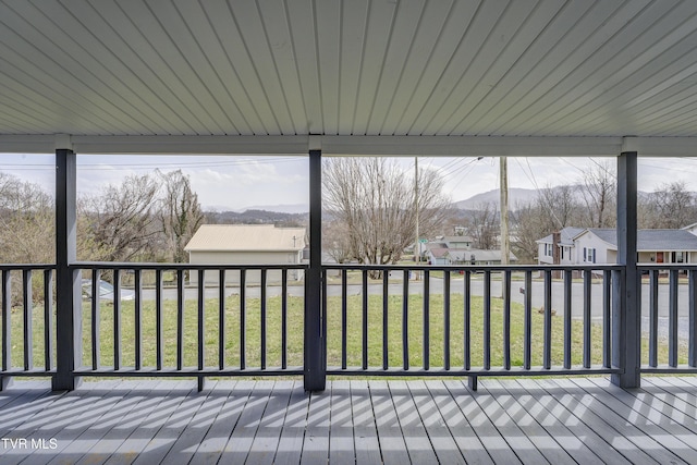 wooden deck featuring a residential view, a yard, and a mountain view