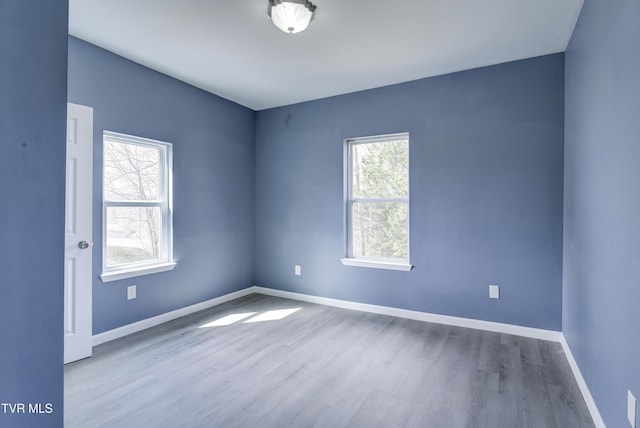 spare room featuring wood finished floors and baseboards