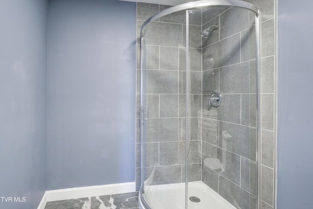 full bath with a stall shower and baseboards