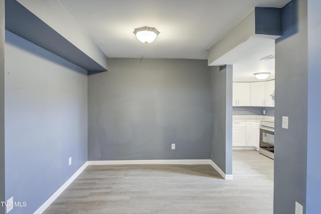 empty room featuring light wood-type flooring and baseboards