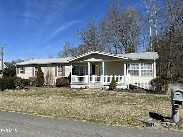 view of front of property with covered porch, a front lawn, and metal roof