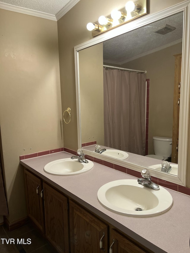 full bathroom featuring double vanity, crown molding, visible vents, and a sink