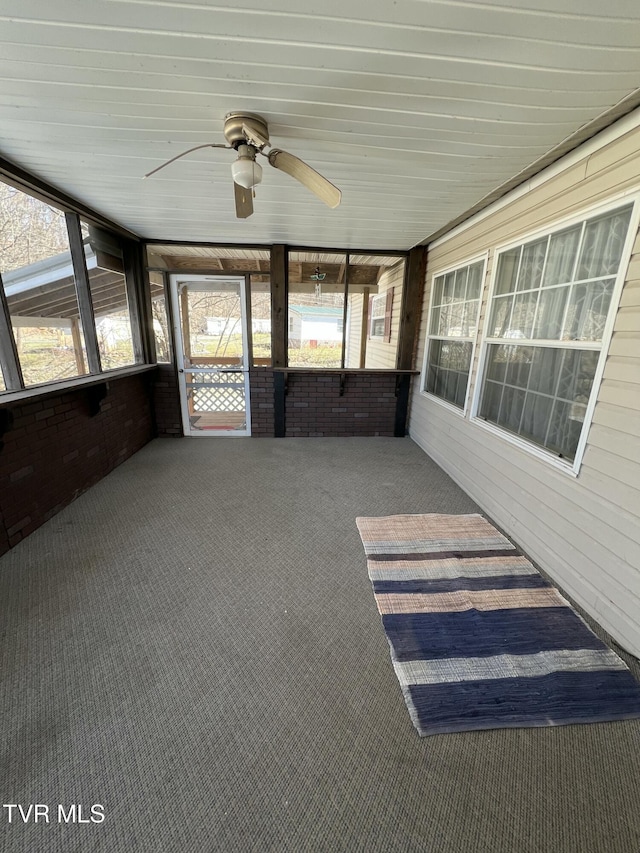 unfurnished sunroom featuring a ceiling fan