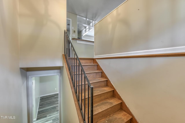 stairs featuring wood finished floors