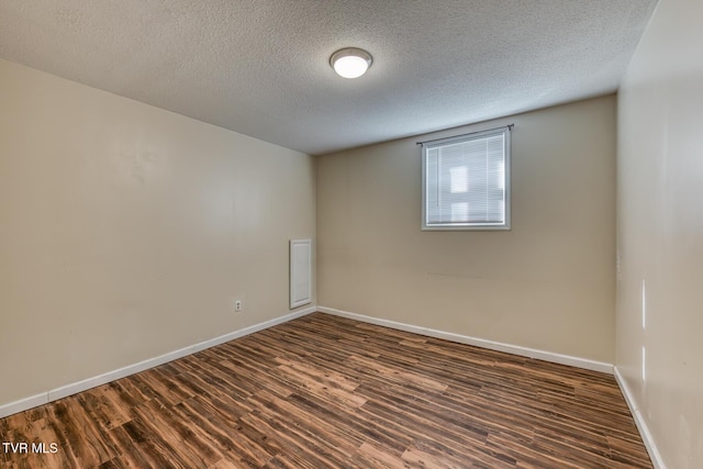 unfurnished room featuring dark wood-style floors, baseboards, and a textured ceiling