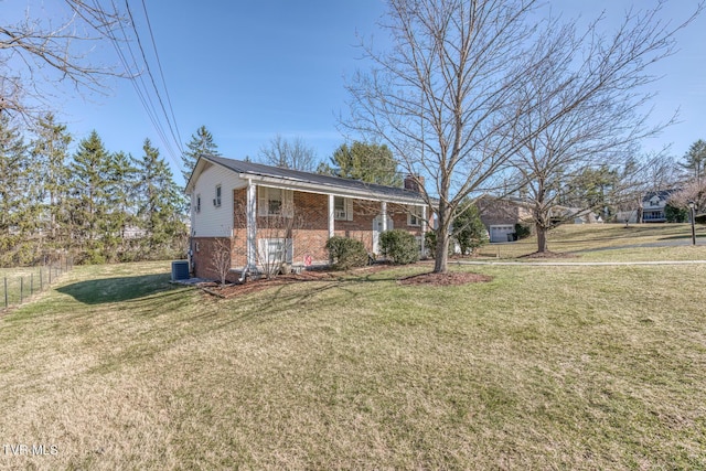 raised ranch featuring a chimney, cooling unit, a front lawn, a porch, and brick siding