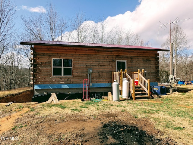 view of front of home featuring log siding and metal roof