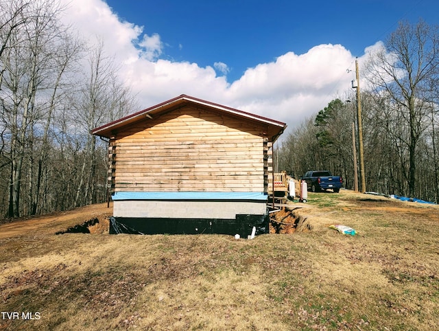 view of side of property with a yard and log siding