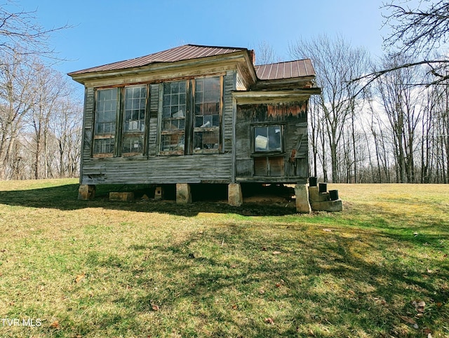 view of front facade featuring a front yard and metal roof