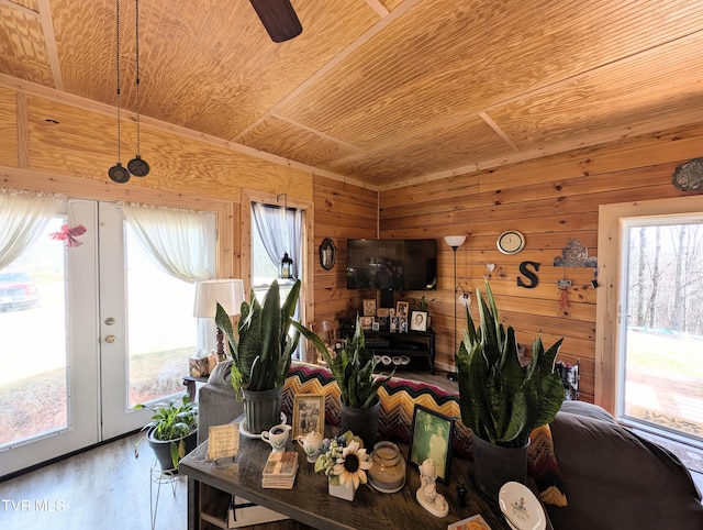 dining room with plenty of natural light, wooden ceiling, and wooden walls