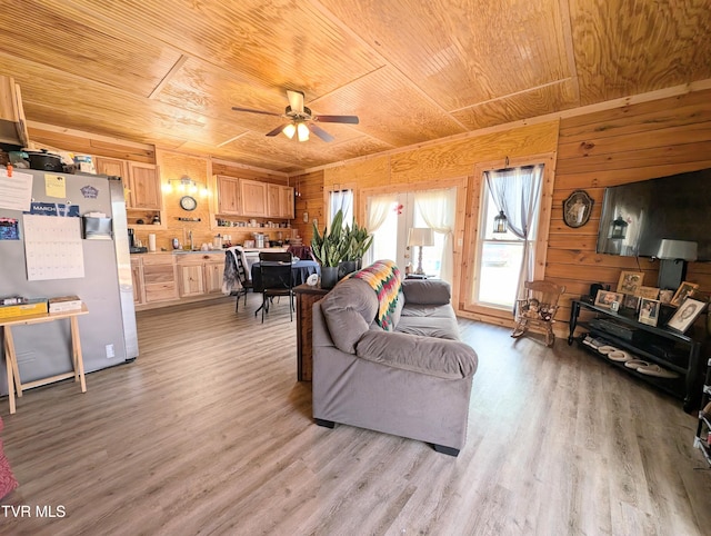 living room featuring wooden ceiling, light wood-style flooring, ceiling fan, and wood walls