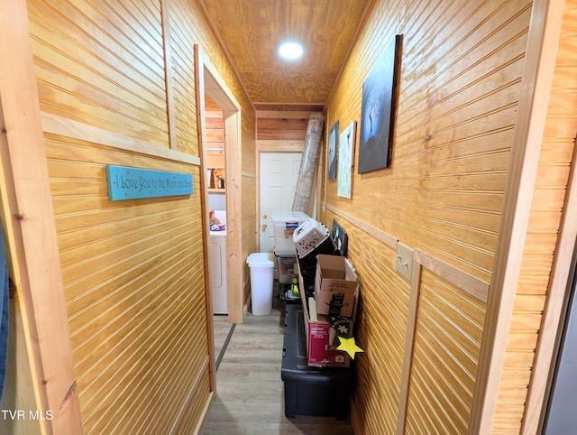 hallway featuring wood ceiling, light wood-type flooring, washer / clothes dryer, and wooden walls