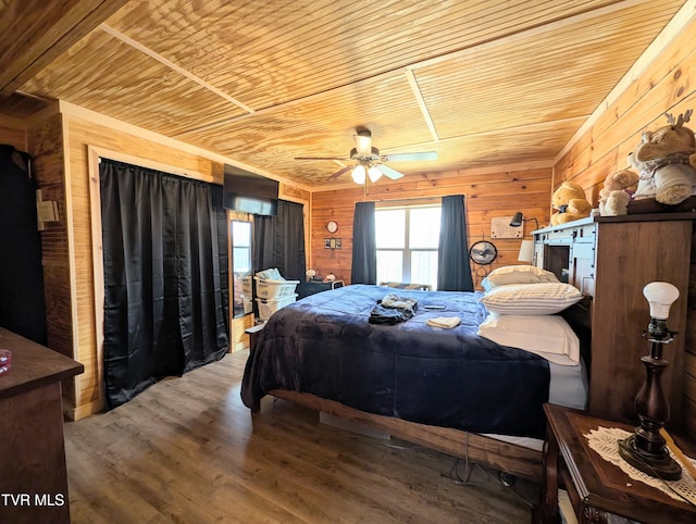 bedroom featuring a ceiling fan, wood finished floors, wood ceiling, and wooden walls