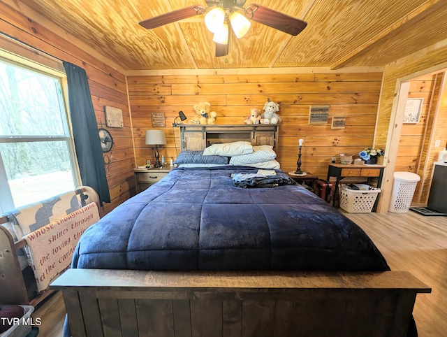 bedroom featuring wooden ceiling, wood finished floors, connected bathroom, and wooden walls