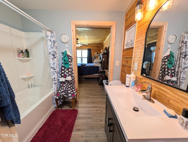 bathroom with shower / tub combo, wood walls, wood finished floors, and vanity