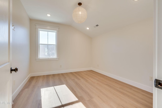 additional living space with light wood-type flooring, visible vents, baseboards, and vaulted ceiling