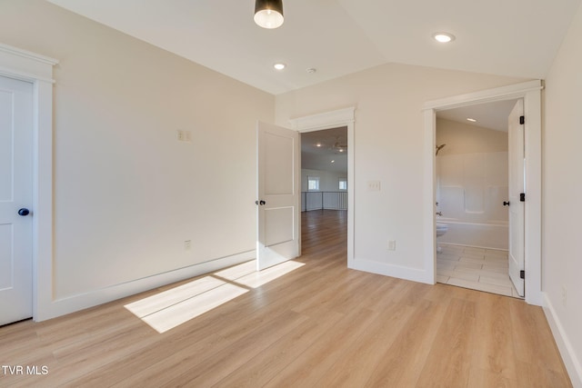 unfurnished bedroom with light wood finished floors, recessed lighting, connected bathroom, vaulted ceiling, and baseboards