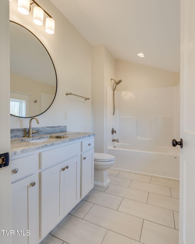 bathroom featuring tub / shower combination, vaulted ceiling, vanity, and toilet