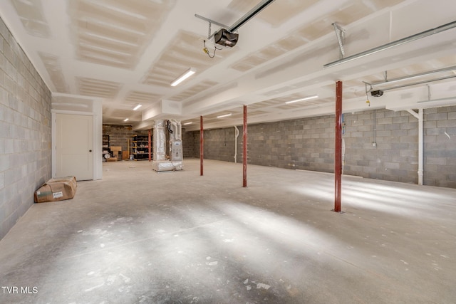 garage with concrete block wall and a garage door opener