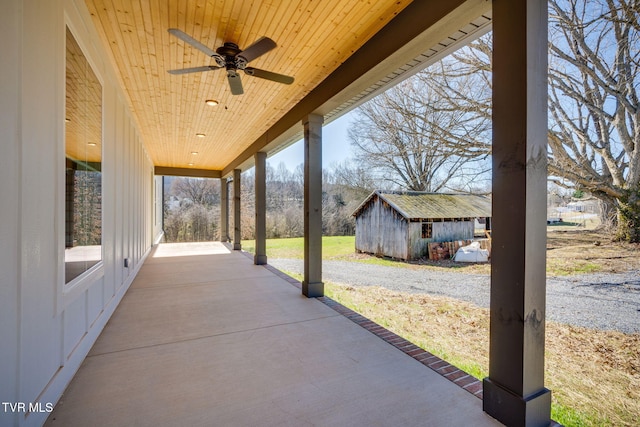 view of patio featuring an outbuilding, a storage unit, and a ceiling fan