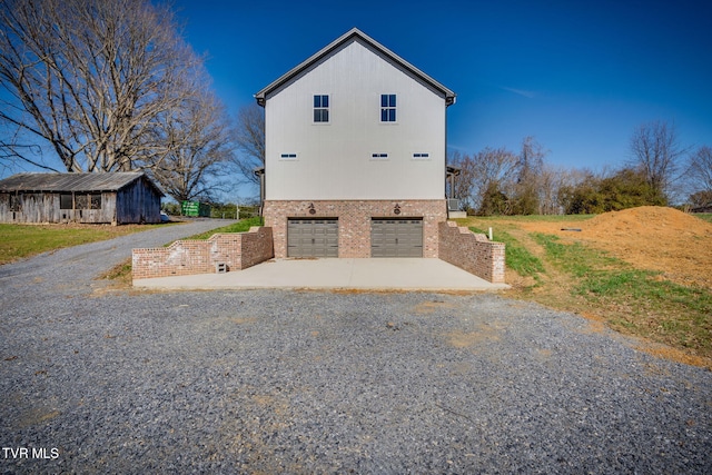 view of property exterior featuring a garage, concrete driveway, and brick siding