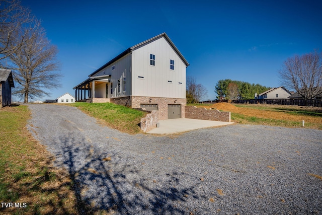 view of property exterior with driveway, an attached garage, and brick siding