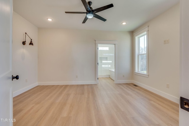 empty room with light wood-type flooring, baseboards, and recessed lighting