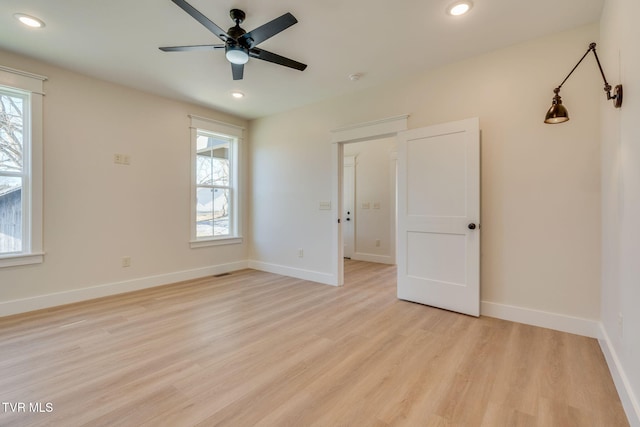 unfurnished room with light wood-style floors, baseboards, a wealth of natural light, and recessed lighting