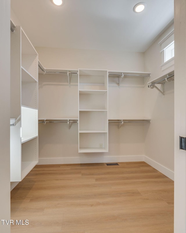 spacious closet featuring wood finished floors and visible vents