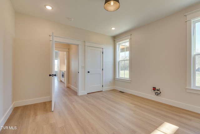 unfurnished room with light wood-style flooring, baseboards, and recessed lighting