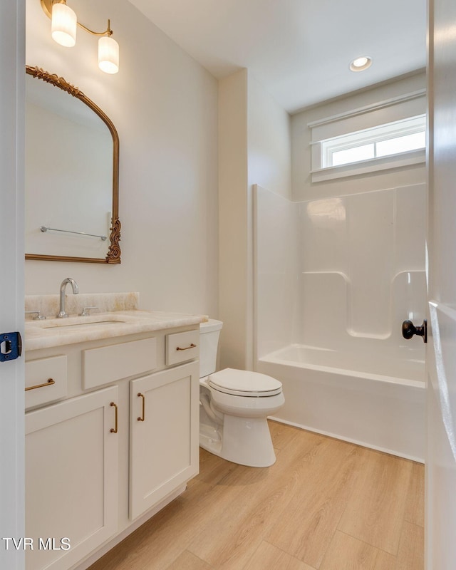 bathroom featuring shower / bathing tub combination, toilet, wood finished floors, vanity, and recessed lighting