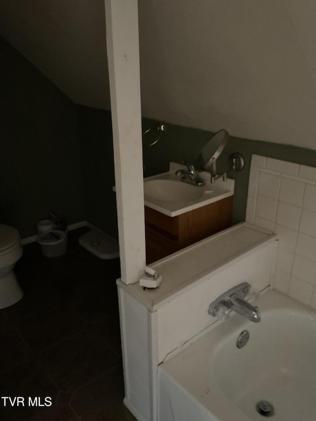 bathroom with a sink, a garden tub, toilet, and tile patterned flooring