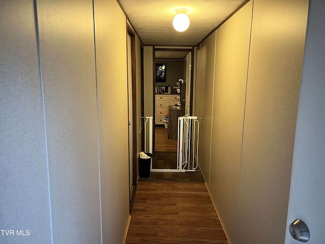 hallway featuring a textured ceiling and dark wood finished floors