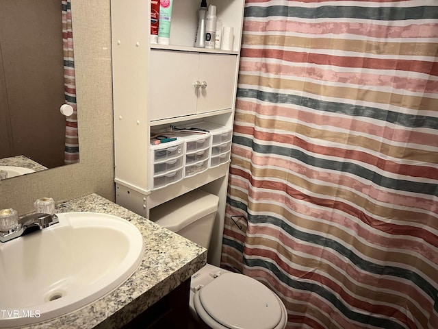 bathroom featuring a shower with shower curtain, vanity, and toilet