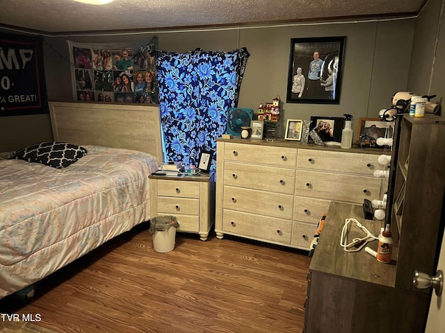 bedroom featuring a textured ceiling and dark wood finished floors