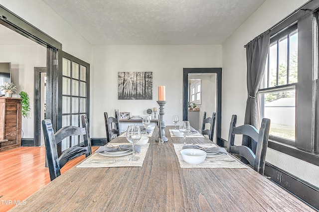 dining space with a textured ceiling and wood finished floors