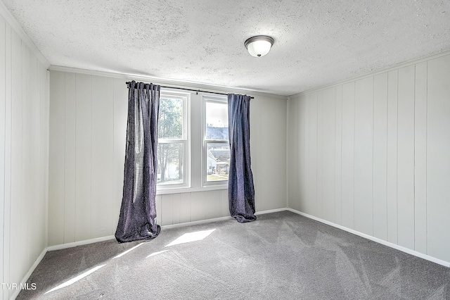 empty room featuring carpet floors, a textured ceiling, and baseboards