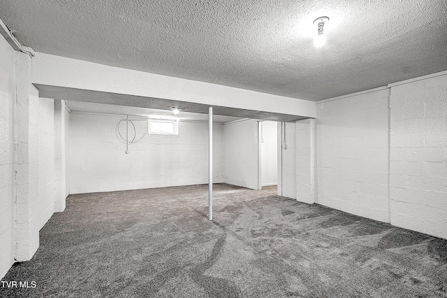 basement featuring a textured ceiling and carpet flooring