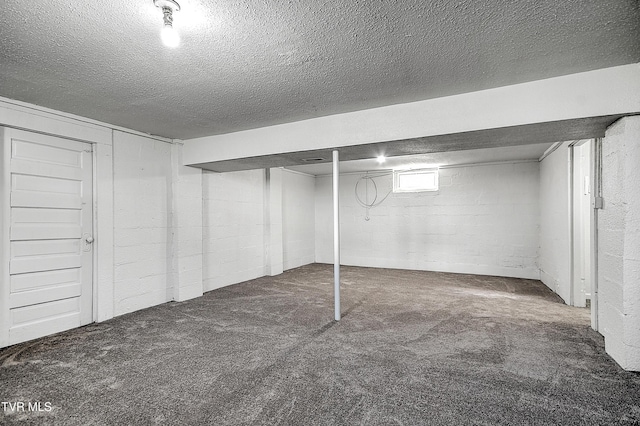 basement featuring a textured ceiling and carpet