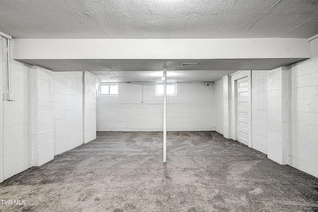 basement featuring a textured ceiling and carpet