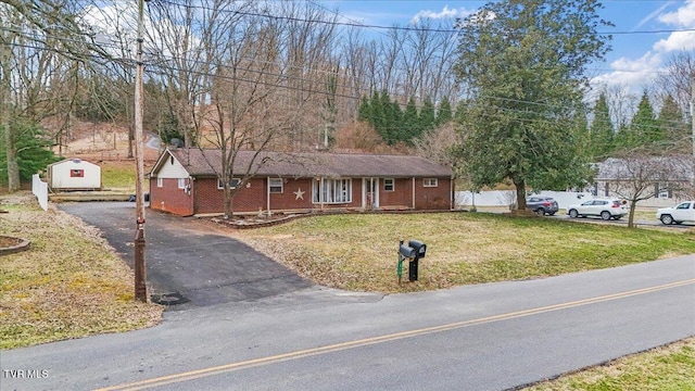 ranch-style house featuring aphalt driveway, a front lawn, and brick siding