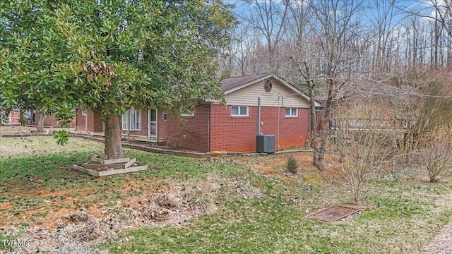 view of property exterior featuring central AC unit and brick siding