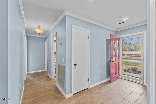 foyer featuring ornamental molding, light wood finished floors, visible vents, and baseboards