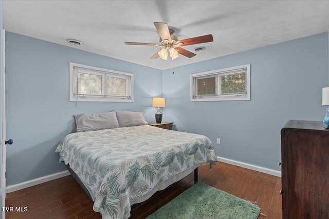 bedroom with hardwood / wood-style flooring, baseboards, multiple windows, and visible vents