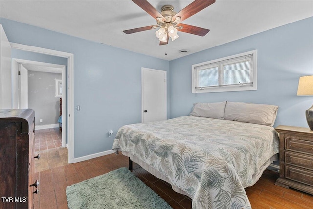 bedroom featuring visible vents, baseboards, ceiling fan, and wood finished floors