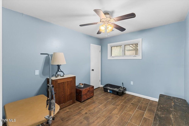 interior space featuring dark wood-style floors, a ceiling fan, and baseboards