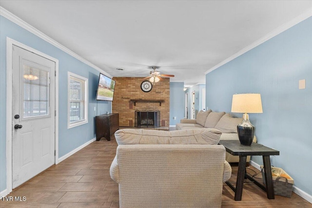 living room with ceiling fan, crown molding, a fireplace, and baseboards