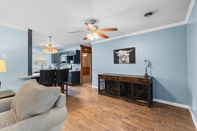 living area featuring crown molding, visible vents, baseboards, and wood finished floors